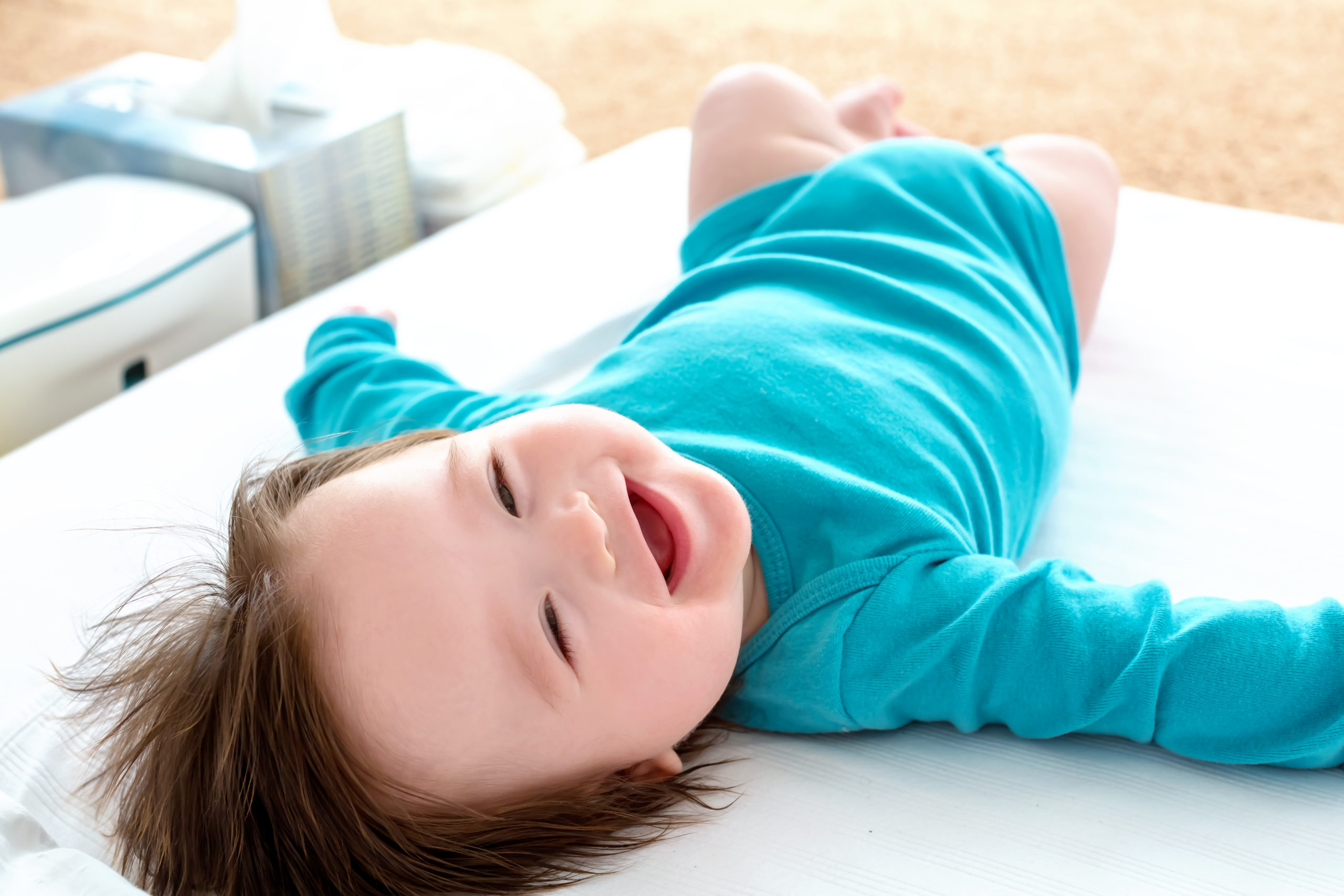 smiling baby boy on changing mat